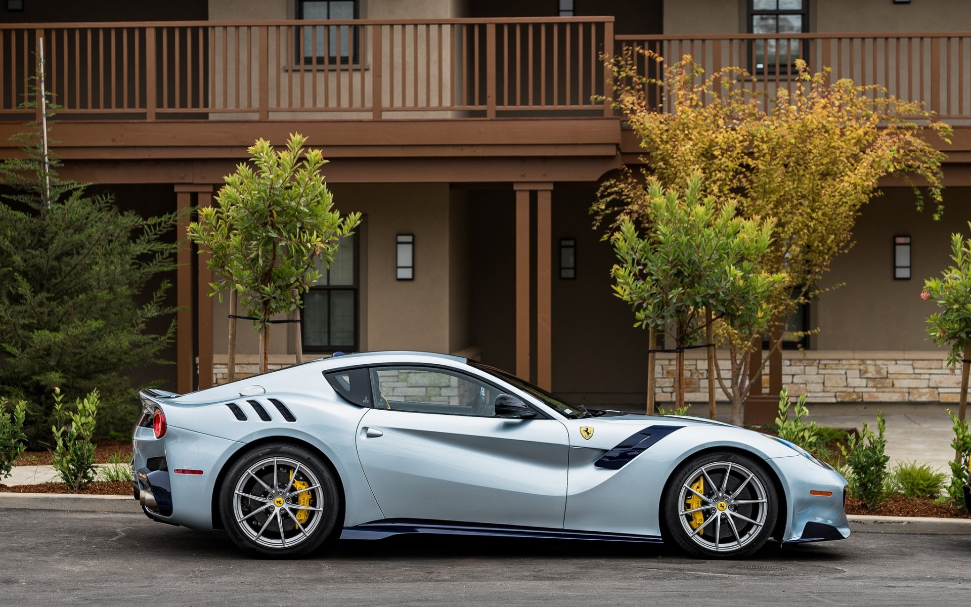 Silver Ferrari F12berlinetta supercar grand tourer parked by a townhouse — sleek silver car vehicle, HD PC desktop wallpaper.
