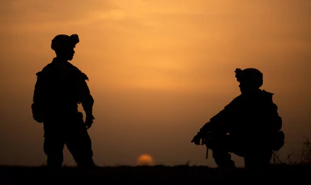 Silhouettes of two soldiers against a vivid sunset sky, captured in HD for a striking military-themed desktop wallpaper background.