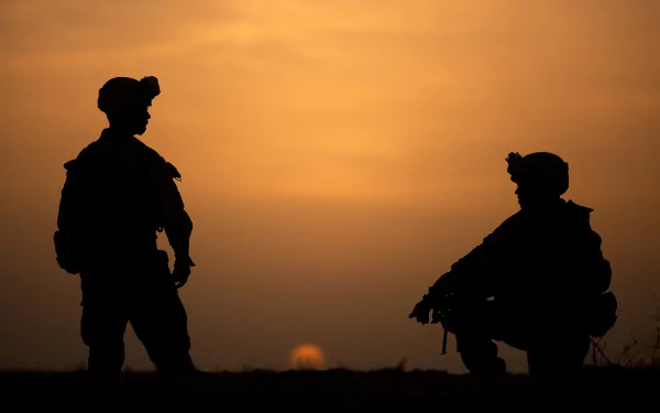 Silhouettes of two soldiers against a vivid sunset sky, captured in HD for a striking military-themed desktop wallpaper background.