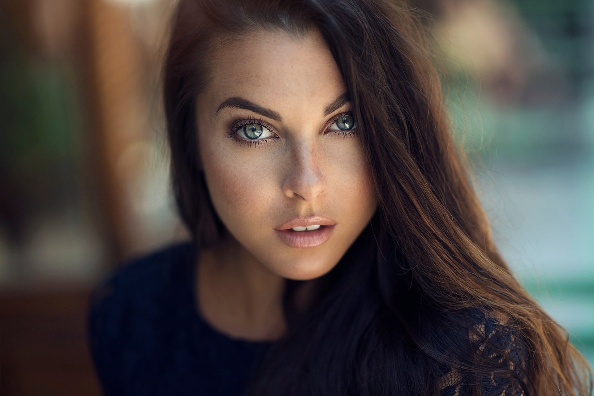 Close-up portrait of a brunette woman with striking blue eyes and soft depth of field, captured in HD quality as a desktop wallpaper and background.