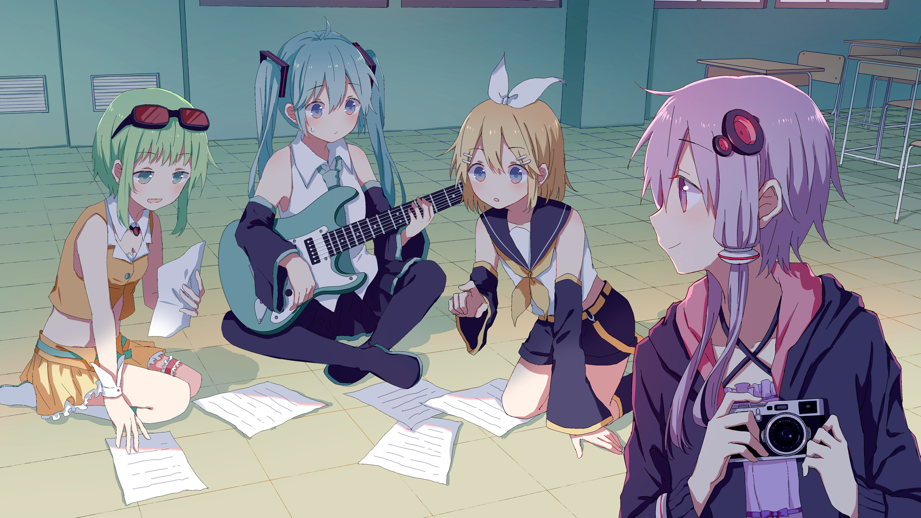 An HD desktop wallpaper featuring Vocaloid characters Yuzuki Yukari, GUMI, Rin Kagamine, and Hatsune Miku. The anime-style image shows them sitting together with musical sheets and a guitar.