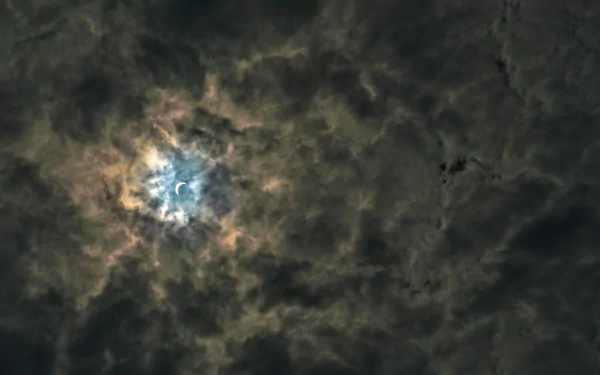 5K Ultra HD PC desktop wallpaper of the moon glowing through swirling dark clouds, a dramatic nature sky background.