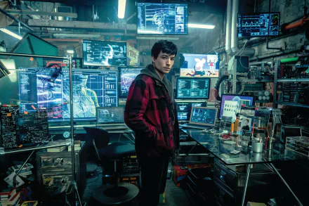 HD PC desktop wallpaper of Ezra Miller as Barry Allen, the Flash, from the 2017 Justice League movie, standing amidst a high-tech lab filled with monitors and equipment.
