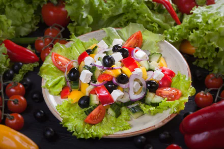 HD desktop wallpaper featuring a vibrant still life of a fresh salad with olives, tomatoes, lettuce, and colorful vegetables.