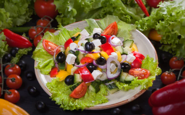 HD desktop wallpaper featuring a vibrant still life of a fresh salad with olives, tomatoes, lettuce, and colorful vegetables.
