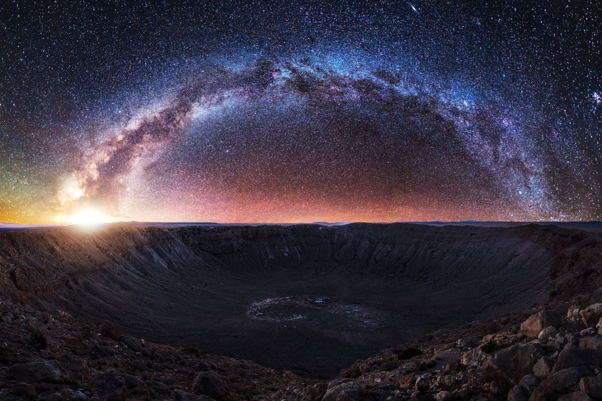 HD desktop wallpaper featuring a vast crater landscape under a starry night sky with the Milky Way arching brilliantly, evoking a sci-fi atmosphere.
