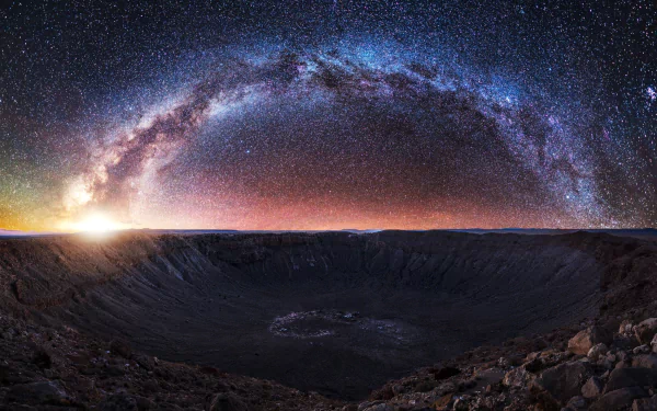 HD desktop wallpaper featuring a vast crater landscape under a starry night sky with the Milky Way arching brilliantly, evoking a sci-fi atmosphere.