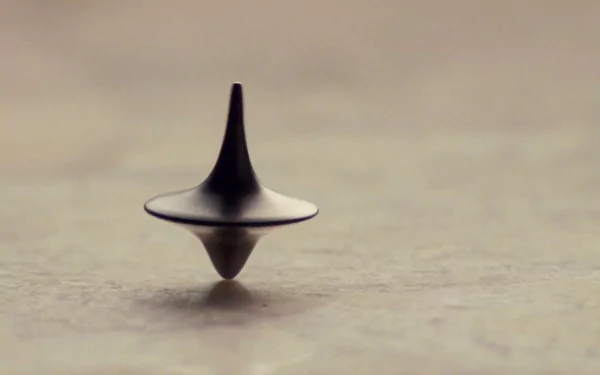 A sleek spinning top, showcasing its design and motion, set against a subtle background. This high-definition image serves as an engaging desktop wallpaper or background.