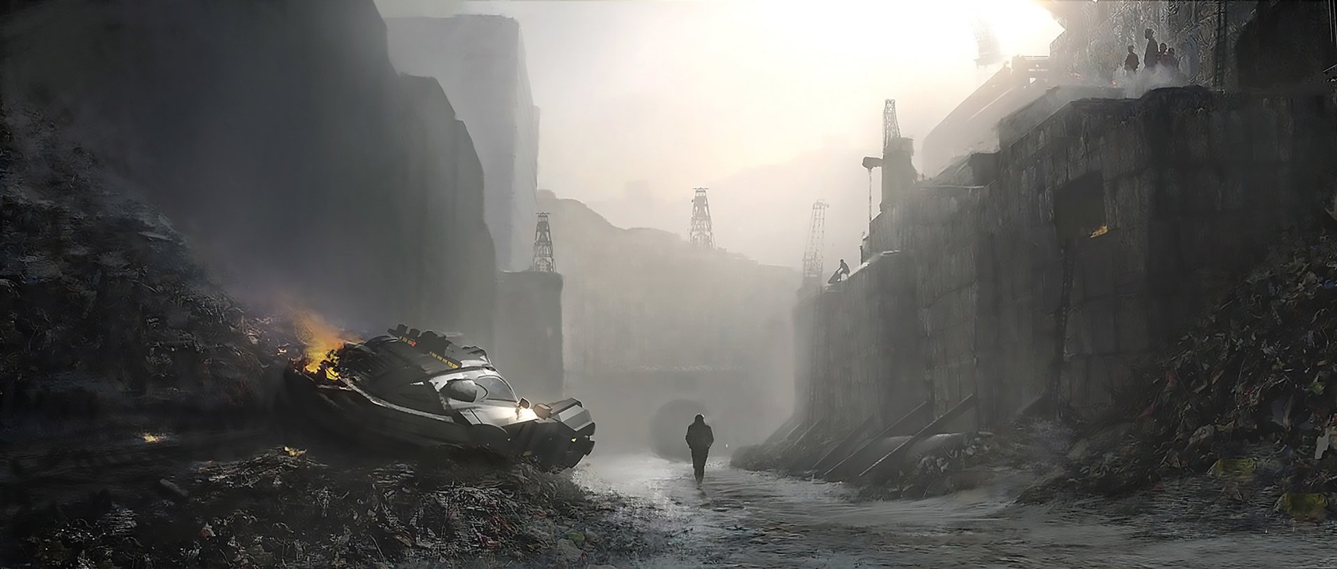 HD sci-fi post-apocalyptic desktop wallpaper showing a lone figure walking through a desolate, ruined industrial landscape with damaged vehicles and hazy skies.