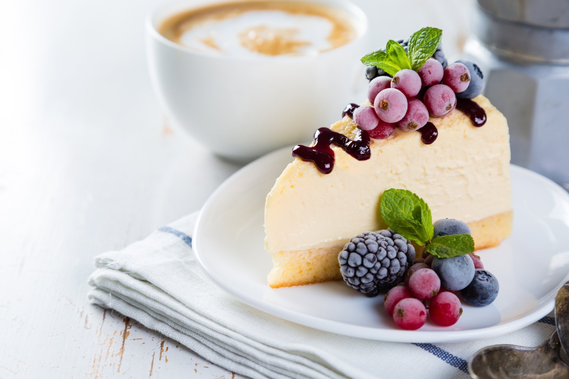 A slice of berry-topped cheesecake dessert on a plate with a cup of coffee, captured in crisp detail as an 8K Ultra HD PC desktop wallpaper background.