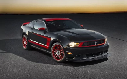 HD wallpaper featuring a sleek black Ford Mustang Boss 302 muscle car with red accents, set against the backdrop of a sunset on an open road.
