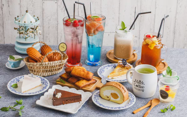 A vibrant still life HD desktop wallpaper featuring an assortment of cakes, desserts, and colorful cocktails and drinks arranged on a rustic wooden table.