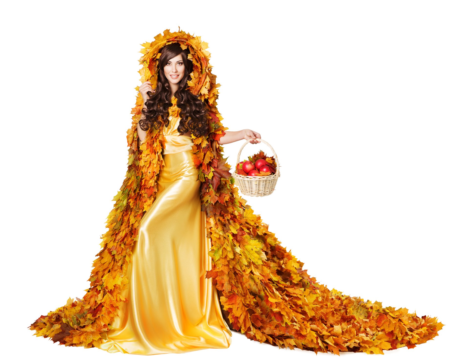 Brunette model in a flowing yellow dress and leaf cloak, smiling with brown eyes while holding a basket of apples — fall 5K Ultra HD PC desktop wallpaper background.
