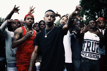 HD wallpaper featuring a focused individual at the center with others making hand gestures in the background. Tagged: 21 Savage.