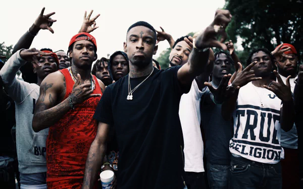 HD wallpaper featuring a focused individual at the center with others making hand gestures in the background. Tagged: 21 Savage.