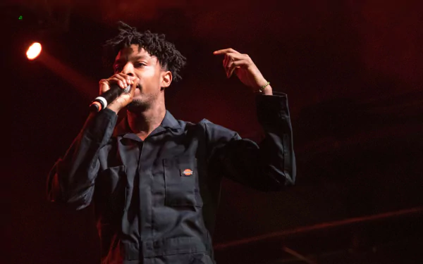 HD desktop wallpaper featuring a performer on stage with a microphone, with warm stage lighting in the background.