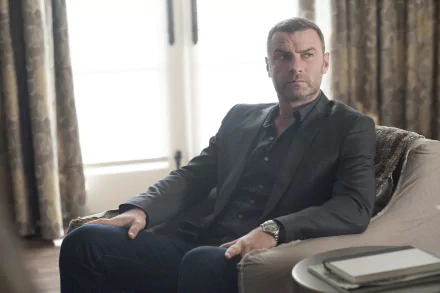 HD desktop wallpaper featuring a character from Ray Donovan, sitting somberly on a sofa in a well-lit room.