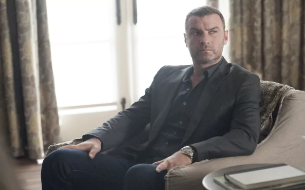 HD desktop wallpaper featuring a character from Ray Donovan, sitting somberly on a sofa in a well-lit room.