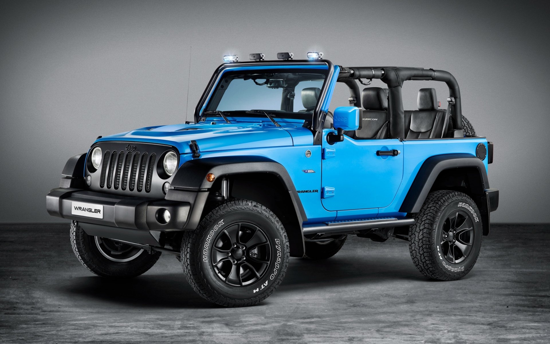 Blue Jeep Wrangler off-road vehicle (open-top) showcased against a neutral backdrop — 2K Quad HD PC desktop wallpaper and background.