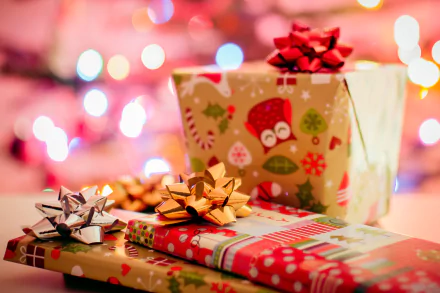 HD PC desktop wallpaper featuring Christmas gifts wrapped with ribbons, set against a colorful bokeh background.