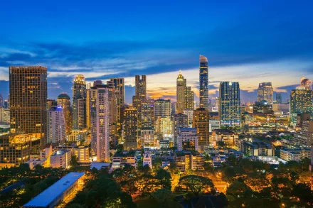 HD desktop wallpaper of Bangkok's vibrant city skyline at night, showcasing illuminated skyscrapers and modern buildings in Thailand's bustling urban landscape.