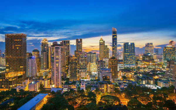 HD desktop wallpaper of Bangkok's vibrant city skyline at night, showcasing illuminated skyscrapers and modern buildings in Thailand's bustling urban landscape.
