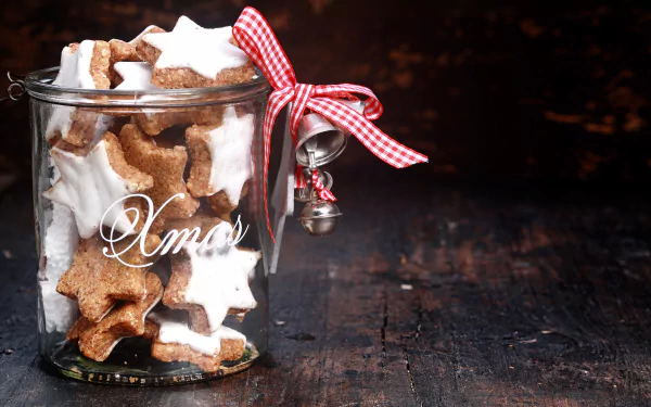 A festive 4K Ultra HD desktop wallpaper featuring a jar filled with star-shaped Christmas cookies, adorned with a red gingham ribbon and small silver bell.