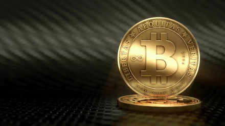 HD wallpaper featuring a shiny Bitcoin on a textured dark background, symbolizing cryptocurrency.