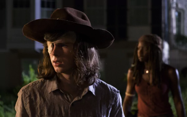 4K Ultra HD wallpaper featuring Carl Grimes (Chandler Riggs) in focus and Michonne (Danai Gurira) blurred in the background from The Walking Dead TV show.