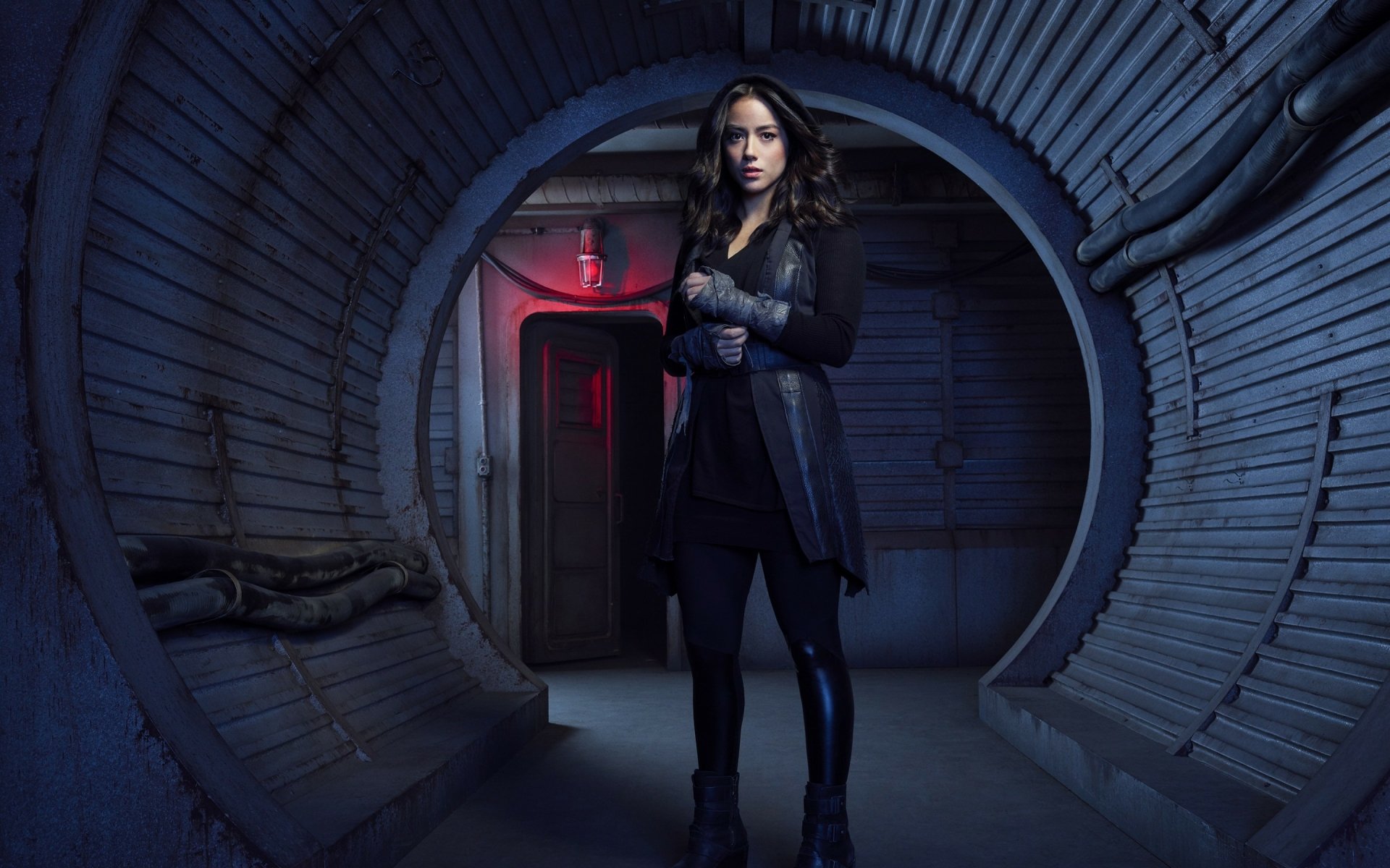 HD desktop wallpaper featuring brunette Marvel's Agents of S.H.I.E.L.D. character Daisy Johnson (Chloe Bennet) with brown eyes, standing in a futuristic, metallic corridor environment.