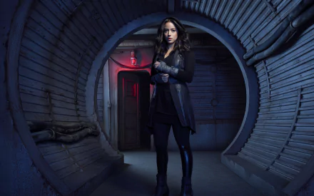HD desktop wallpaper featuring brunette Marvel's Agents of S.H.I.E.L.D. character Daisy Johnson (Chloe Bennet) with brown eyes, standing in a futuristic, metallic corridor environment.