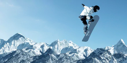 Snowboarder performing a jump against a backdrop of snowy mountain peaks, captured in stunning 4K Ultra HD for a dynamic sports desktop wallpaper.