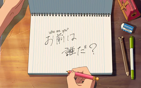 A hand writes Who are you? in English and Japanese kanji in a notebook using a pencil on a wooden desk, with an eraser, pens, and pencil case nearby. This HD desktop wallpaper is inspired by the anime Your Name.”