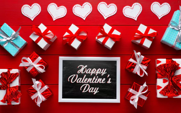 A vibrant 4K Ultra HD Valentine's Day desktop wallpaper featuring a Happy Valentine's Day message surrounded by gift boxes and stitched heart decorations on a red background.