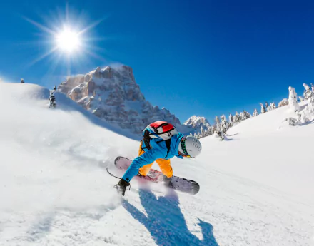 A snowboarder navigates fresh powder in a stunning winter mountain landscape, with bright sunshine illuminating the scene and showcasing the thrill of winter sports.