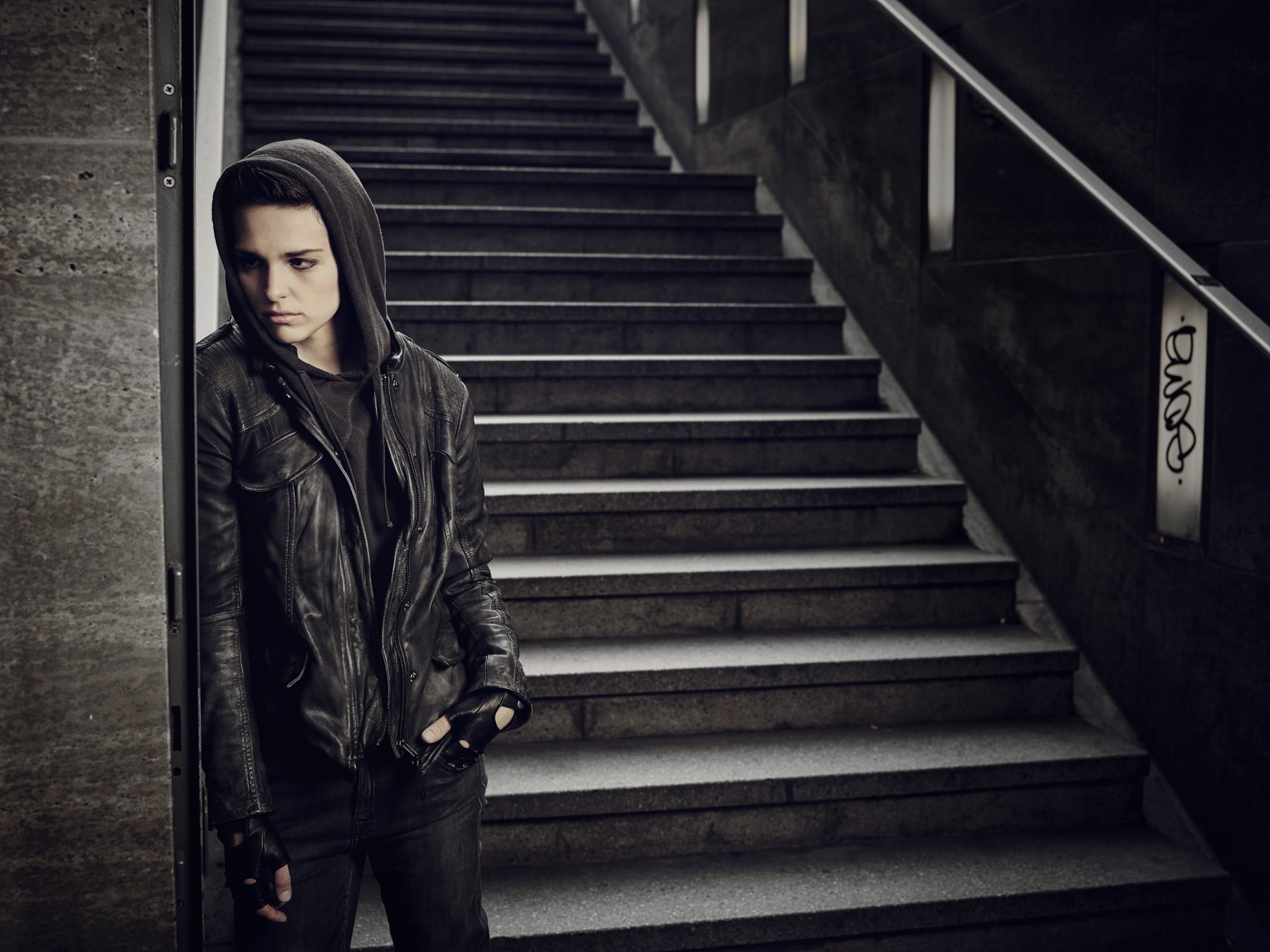 HD wallpaper featuring a person in a leather jacket standing on stairs, evoking a moody, counterpart-themed ambiance.