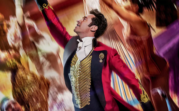 HD wallpaper of The Greatest Showman, featuring a performer in a vibrant ringmaster costume with an arm raised mid-performance.