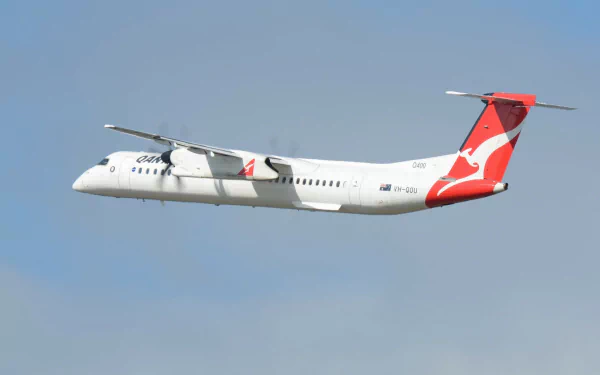 De Havilland/Bombardier Dash 8 passenger aircraft in flight against a clear blue sky — HD PC desktop wallpaper background.