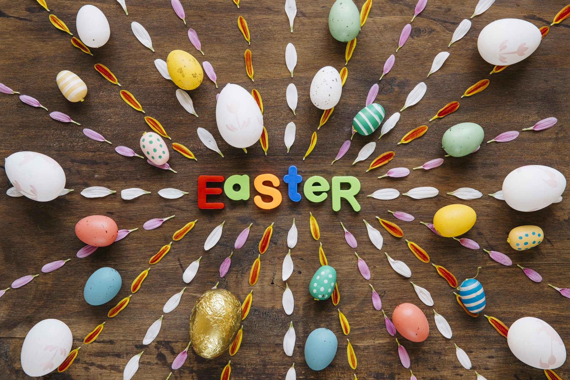Colorful Easter eggs arranged in a radial pattern around the word Easter on a wooden background, designed as a 4K Ultra HD holiday desktop wallpaper.