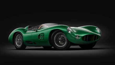 HD desktop wallpaper of a classic green Aston Martin DBR1. The sleek, vintage car stands out against a black background, showcasing its iconic and elegant design.