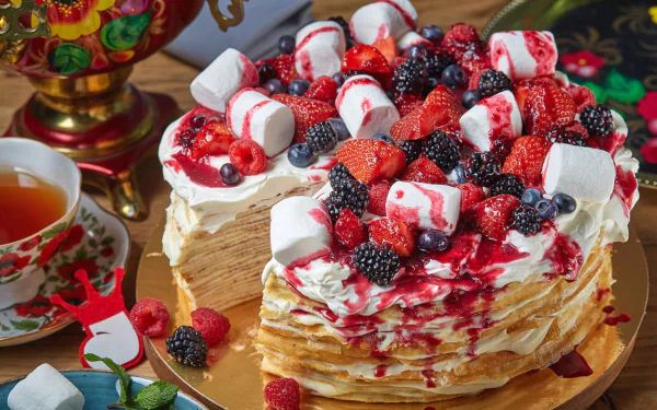 A stack of crêpes topped with whipped cream, marshmallows, and mixed berries including blueberries, strawberries, and raspberries, styled as a vibrant still life HD desktop wallpaper.