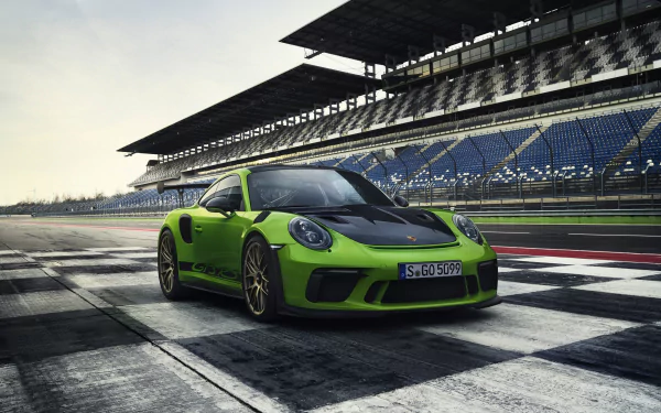Green Porsche 911 GT3 race car parked on a racetrack under a cloudy sky, captured in HD for a striking PC desktop wallpaper.