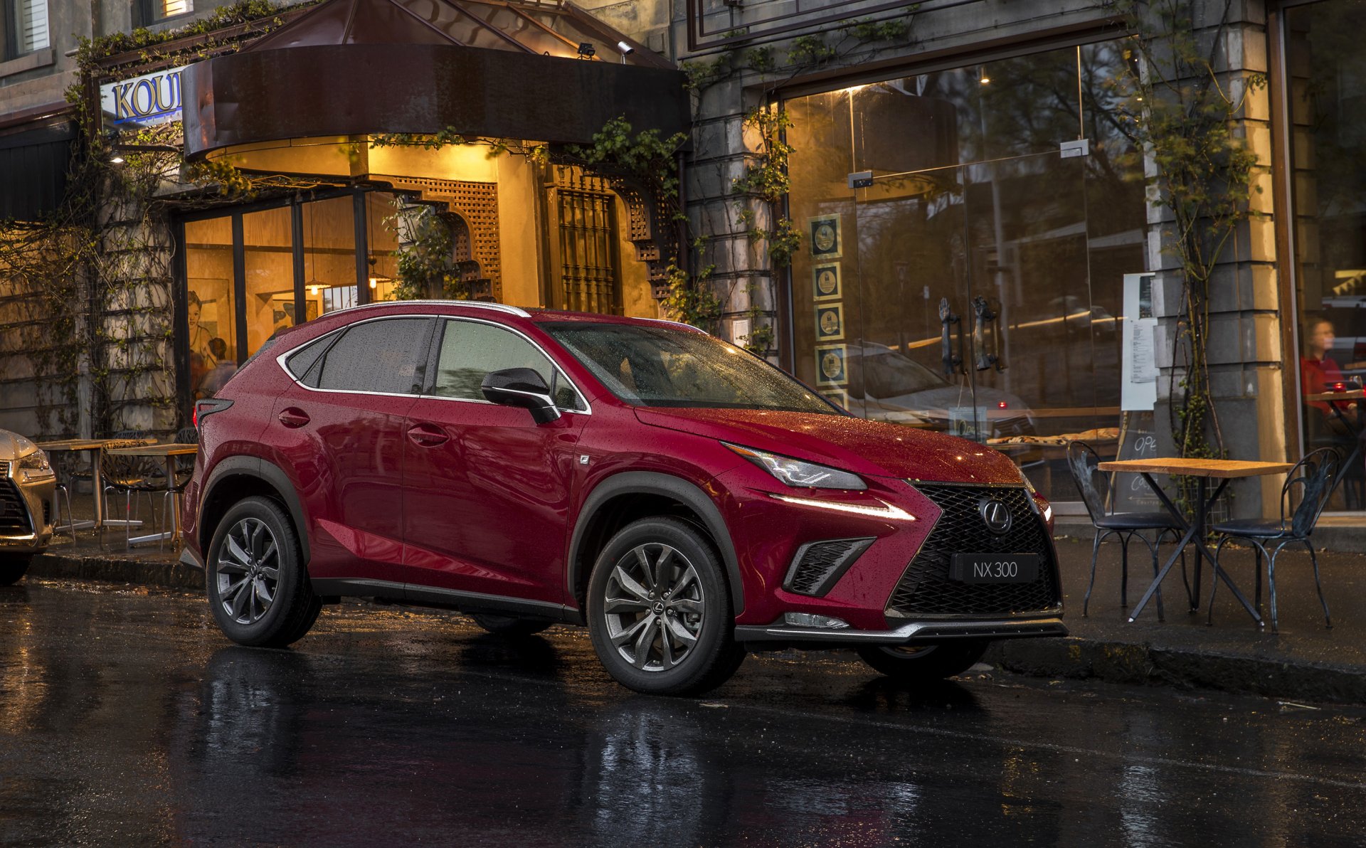 Red Lexus NX SUV parked on a wet city street at night outside a café — 2K Quad HD PC desktop wallpaper/background showcasing Lexus car and vehicle.