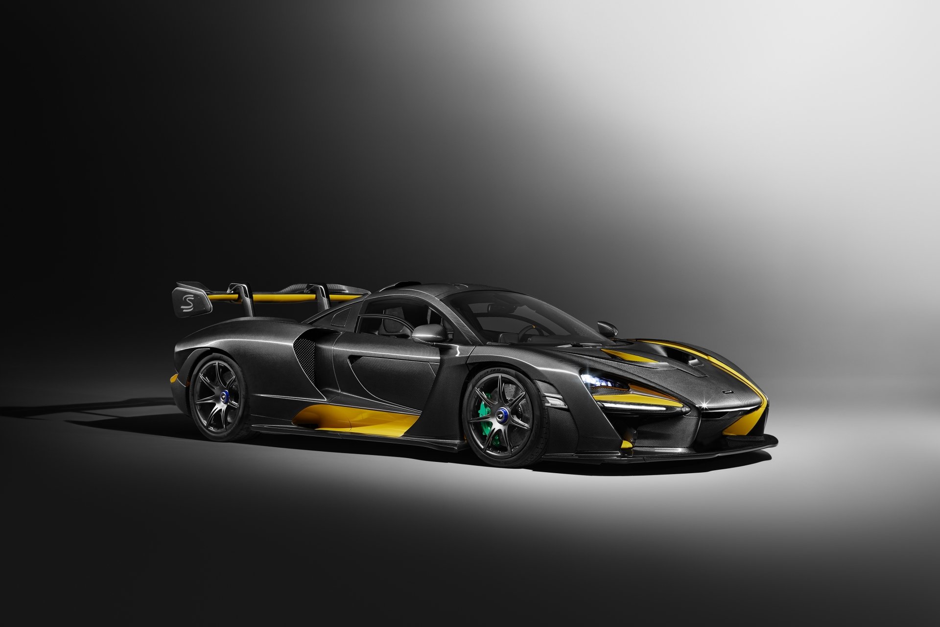 Silver McLaren Senna supercar showcased in a sleek 4K Ultra HD desktop wallpaper with dynamic lighting highlighting its aerodynamic design and details.