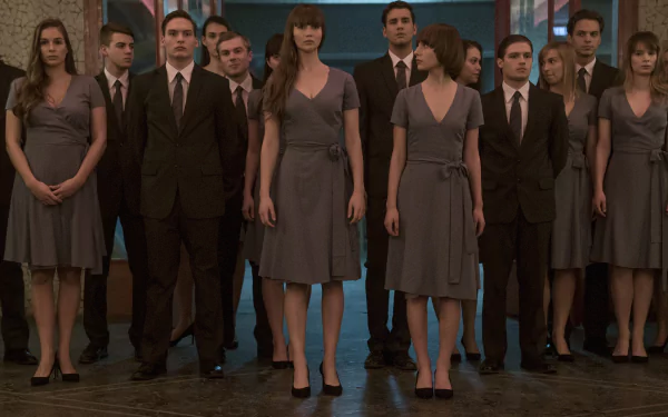 HD wallpaper of a scene from Red Sparrow featuring a group of people in formal attire, standing in a dimly lit room.