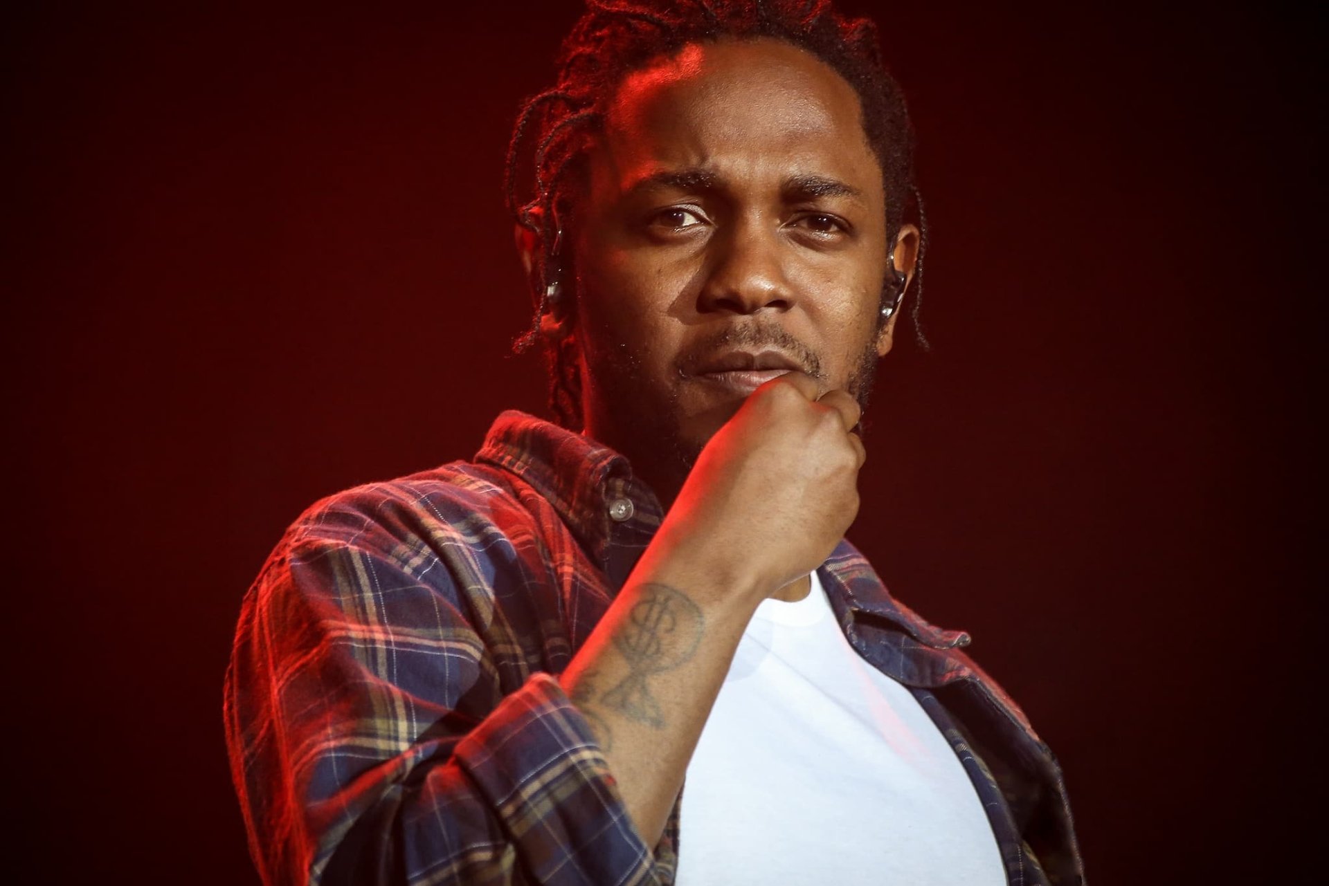 HD wallpaper featuring a contemplative person on stage, providing an artistic background for Kendrick Lamar fans.