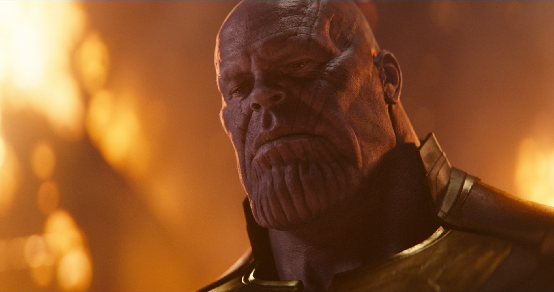 HD PC desktop wallpaper featuring Thanos, portrayed by Josh Brolin, from the movie Avengers: Infinity War with dramatic orange lighting.