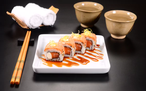 5K Ultra HD PC desktop wallpaper — still-life sushi: plated seafood rolls with sauce and lemon zest, chopsticks and tea cups on a black surface.