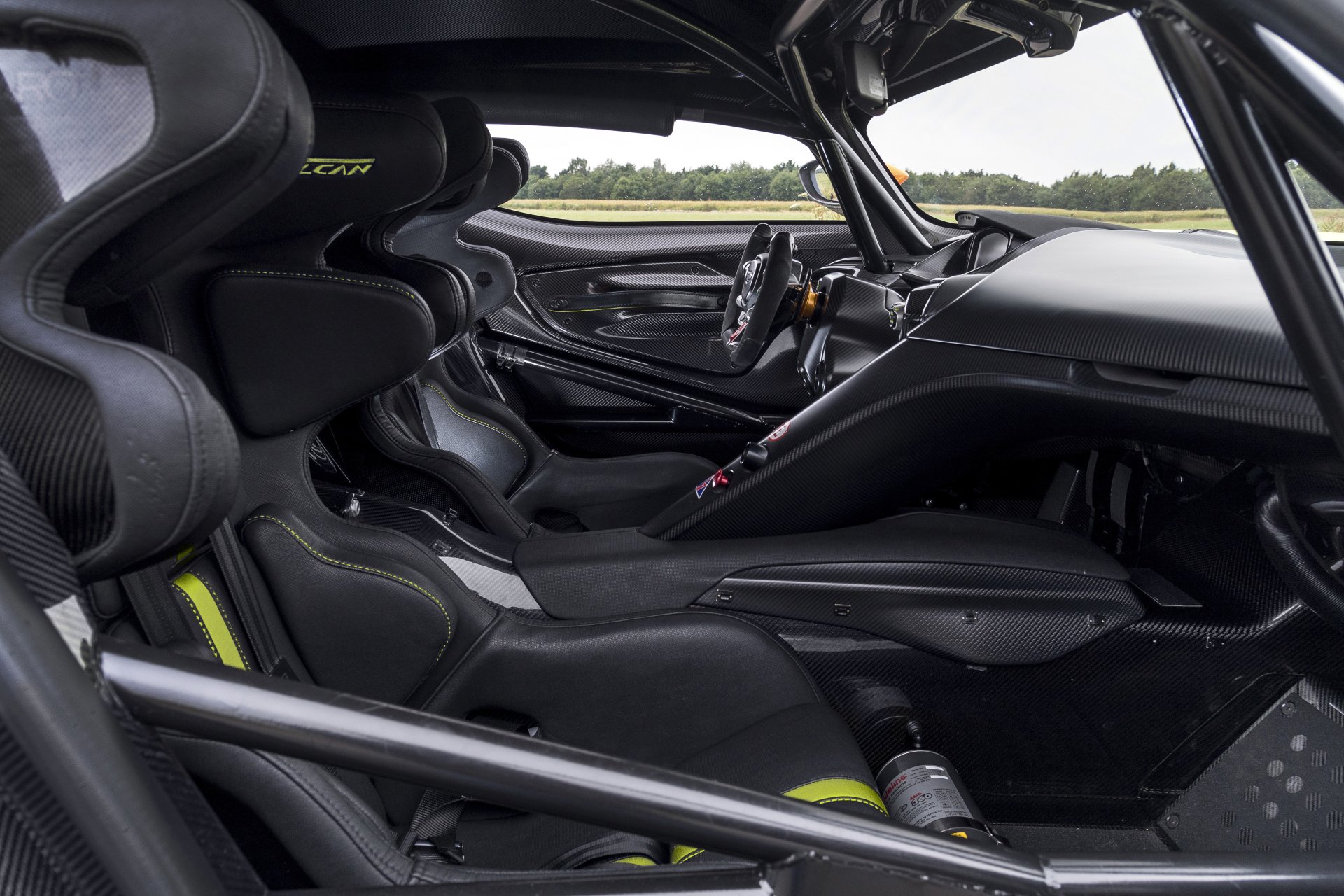 5K Ultra HD PC desktop wallpaper showing the carbon-fiber cockpit interior of an Aston Martin Vulcan AMR Pro, race seats, roll cage and steering wheel.