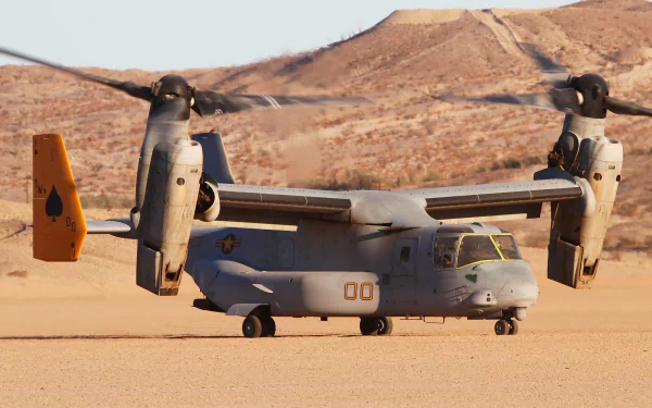 Bell Boeing V-22 Osprey transport aircraft with spinning rotors on a desert runway, featured as an HD PC desktop wallpaper and military aircraft background.